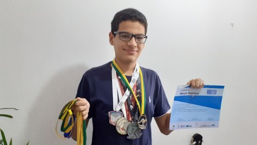 Jairon com medalhas e certificados que conquistou em olimpíadas científicas.